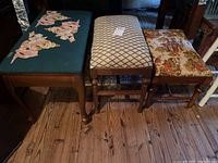 Three wooden benches side-by-side on wooden floor, showing different cloth tops and wood frames.