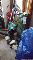 Photo showing the garden tools in a garage including Parkside grass trimmer in box, Worx trimmer and hedge trimmer for context.