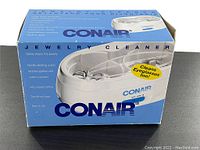 Blue and white Conair jewelry cleaner box showing product name and product photo, box says 'Cleans Eyeglasses Too!'