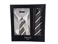 Closed box showing white dress shirt and two matching ties with black and white diagonal stripes, branded Gigante Mode