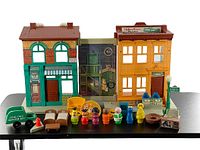 Overview of Sesame Street playhouse with figures and accessories arranged in front