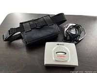 Photo showing the carry bag, Memorex cassette player, and headphones on a table.