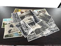 Photo showing a pile of vintage postcards mostly black and white depicting Banff scenes including wildlife, landscapes, and historic buildings.