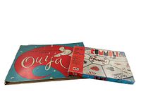 Photo showing vintage Ouija board original box with red and blue mystical design and Rummoli Deluxe game box featuring playing card illustrations.
