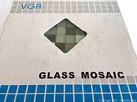 Close-up of VGA box with diamond-shaped cutout revealing glass mosaic tiles inside, showing tile arrangement and colors.