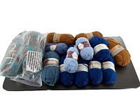 Photo showing all skeins of yarn laid out, including brown, light and dark blue, and mahogany colored yarns