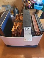 Box with vintage vinyl records in worn paper sleeves, including Paul Weston and South Pacific albums.