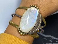 Cuff worn on wrist showing scale and patinated surface.
