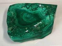 Front view of polished malachite slab showing bowl indentation and banded pattern