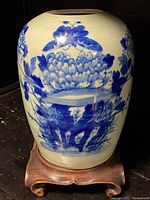 Front view of porcelain jar on hardwood stand showing overall form and decoration