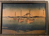 Front view of framed woodblock print showing boats on water with Mount Fuji in background