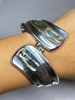 Bracelet view showing abalone inlay and silver surface wear.