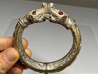 Front view of hinged bangle showing paired serpent heads meeting at clasp