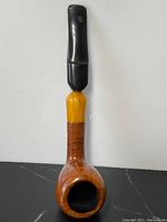 Full length photo of antique smoking pipe with amber and burl wood parts and black mouthpiece, showing overall condition and design.