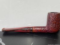 Side view of the antique cherry burl wood smoking pipe with amber mouthpiece showing textured wood and marbled amber tip.