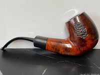 Full side view of the antique Calabresi briar pipe showing its curved shape and metal pinecone decoration on the bowl.