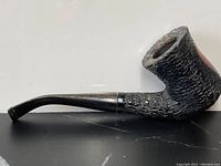 Side view of the antique burl pipe showing the textured black finish and curved stem.