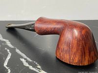 Side angle view showing the curved burl wood bowl and black stem with polished finish.
