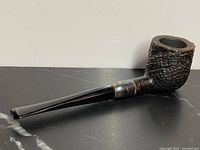 Full side view of antique pipe showing textured burl wood bowl, sterling silver band, and black stem.