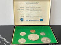 Front view of the coin set in display case showing coins arranged on green felt with informational text on inner lid describing wildlife designs on each coin.