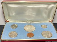Front view of Canadian Centennial coin set inside presentation case showing five coins.