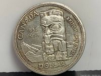 Front side of the 1958 Canadian silver dollar showing the totem pole design and inscriptions including 'CANADA', '1858 1958', 'BRITISH COLUMBIA', and 'DOLLAR'.