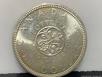 Reverse side showing floral wreath centennial design with inscriptions CHARLOTTETOWN, QUEBEC, and dates 1864-1964 DOLLAR.