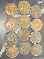 Top side of 12 British farthing coins showing portraits of various British monarchs including Edward VII and George V with worn and aged surfaces.