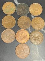 Ten early British pennies showing various states of wear and designs including seated Britannia and dated examples like 1920.
