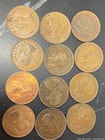 Obverse side of various British pennies showing Queen Elizabeth II and King George VI profiles.