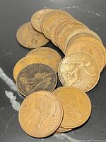 Twenty early British pennies arranged in a stack and scattered showcasing obverse and reverse sides including Queen Victoria bust and seated Britannia