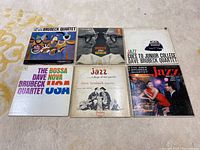 Six vintage vinyl LP albums by Dave Brubeck Quartet arranged on carpet showing front covers