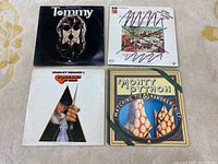 Four movie album vinyl records including Tommy, A Clockwork Orange, and two Monty Python albums with varying cover art and condition