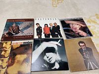 Six vinyl albums laid out: Stevie Wonder Talking Book, Pretenders self-titled, The Cars Shake It Up, Van Morrison Moondance, Marianne Faithfull Broken English, Elvis Costello This Year's Model.