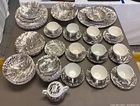 Wide view of 66 piece Myott Royal Mail Ironstone set showing arrangement of plates, bowls, cups, saucers, and covered sugar bowl in brown transferware pattern.