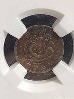 Obverse view of the coin showing the coiled dragon design in tablet holder.
