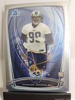 Front of the 2014 Topps Bowman Chrome Aaron Donald rookie card showing the player in Los Angeles Rams practice gear with a gold signature across the front.