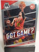 Front side of Trae Young 2019 Panini Mosaic Prizm basketball card showing player in mid-air, signed with blue ink.