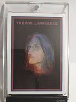 Photo of the encapsulated Trevor Lawrence rookie card front showing the portrait artwork and card title in acrylic case.