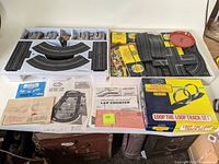 Black plastic tray containing additional track sections, small original boxes and red loop support