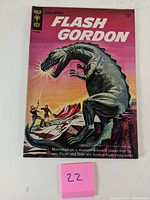 Front cover of the Flash Gordon #1 comic book showing the title and dinosaur monster fight scene.
