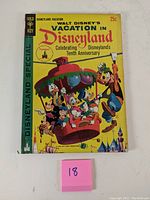 Front cover of the comic book showing Disney characters on a carousel with vibrant yellow background, celebrating Disneyland's tenth anniversary.