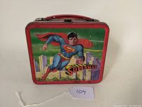 Front view of the vintage steel Superman lunchbox showing Superman flying over the city.