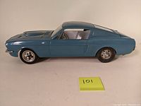 Side view of blue metal vintage Wen Mac AMF Mustang Fastback car model showing body details and wheels