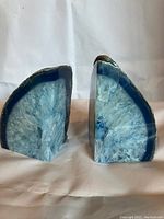 Front view of both blue geode bookends showing natural and cut surfaces.