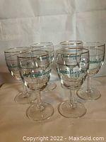 Set of six vintage Irish coffee glasses on white background, displaying green lettering, shamrocks, and gold-rimmed tops.
