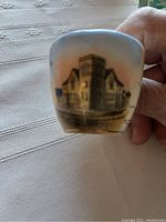 Cup depicting a building, possibly a souvenir or commemorative design on one of the cups.