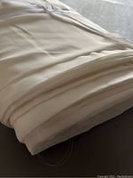 Close-up view of folded white sheer fabric showing smooth texture and translucency