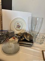 Full lot including glass dishes, bowls, rabbit sculpture on books, candle holders, and large glass vase.