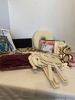 Wooden kids mask crafts, monkey cutout, pink sparkling netting, stacks of cards and invitations, neck supporter cushion